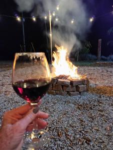 una persona sosteniendo una copa de vino frente al fuego en Alto Maanaim, en Sapucaí-Mirim