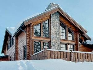 a wooden house with a fence in the snow at Mountain Lodge With Views Over Idre in Idre