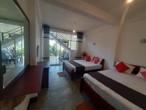 a hotel room with two beds and a balcony at Green Villa Ella in Ella
