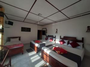 a room with two beds and a table and a couch at Green Villa Ella in Ella +21 photos