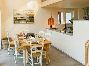 a kitchen and dining room with a wooden table and chairs at Modern Loft House In The Woods Near Gullabo in Gullabo