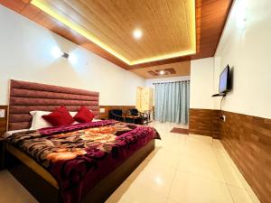 a bedroom with a large bed with red pillows at Guruchhaya hotel and cottages in Manāli