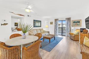 a living room with a table and chairs at 33C Lighthouse Point in Tybee Island