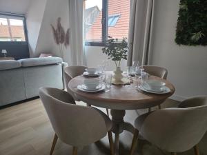 une table à manger avec des chaises et une table avec des verres dans l'établissement La Valentine - Appartement proche marché de Noël - Wifi, à La Celle-sous-Gouzon