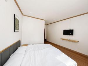 a bedroom with a bed and a tv on a wall at Demi Cafe and Hostel in Vientiane