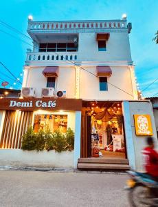 a person riding a motorcycle in front of a donut cafe at Demi Cafe and Hostel in Vientiane