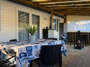 a table on the back porch of a house at Bungalow tout confort in Hourtin