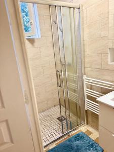 a shower with a glass door in a bathroom at Maison Bon Séjour in Livry-Gargan