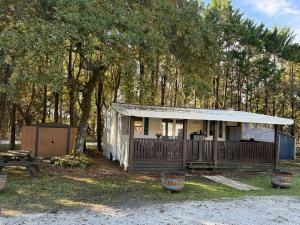 a small house with a porch and a picnic table at Bungalow tout confort in Hourtin