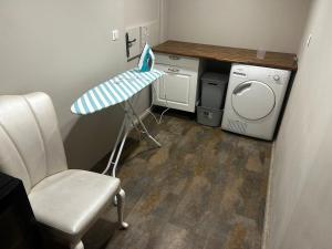 a small room with a washing machine and a chair at Appartement in Oberschaeffolsheim