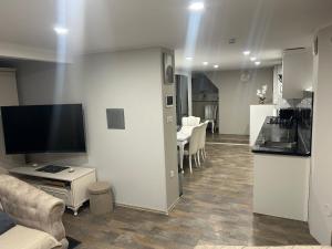 a living room with a kitchen and a living room with a television at Appartement in Oberschaeffolsheim