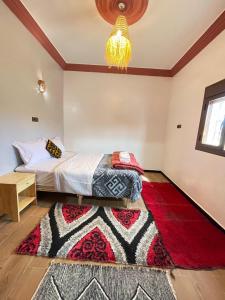 Schlafzimmer mit einem Bett und einem roten Teppich in der Unterkunft Auberge Restaurant Camping Taghzout in Agoudal + 48 Fotos