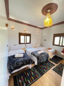 ein Schlafzimmer mit zwei Betten und einem Kronleuchter in der Unterkunft Auberge Restaurant Camping Taghzout in Agoudal