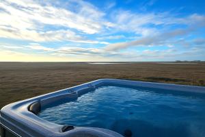 a hot tub in the middle of a field at Hítarneskot - Private hot tub Cottages in Hítarneskot +35 photos
