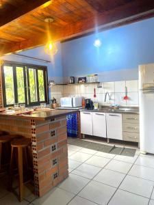 a kitchen with white cabinets and a blue wall at Apê Beira mar: Ar, mirante e Vista Mar – 6 Pessoas in Imbituba