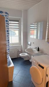 a bathroom with a sink and a toilet and a tub at Fewo Monteurwohnung SAW II in Salzwedel