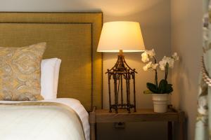 łóżko z lampką na stole z kwiatami w obiekcie Balmoral Arms w mieście Ballater