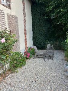 a garden with two chairs and a bench and flowers at Chambre privée autonome in Ouilly-du-Houley