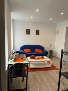 een woonkamer met een blauwe bank en een tafel bij Violette 2 in La Souterraine