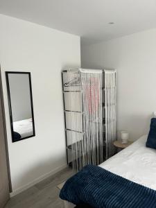 een slaapkamer met een bed met een spiegel en een plank bij Violette 2 in La Souterraine +3 foto's