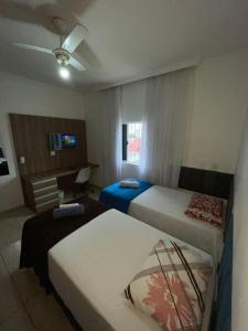 a hotel room with two beds and a desk at Hostel Castelo in Belo Horizonte +32 photos