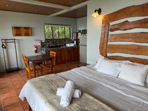 a bedroom with a large bed and a kitchen at Rainbow Valley Lodge Costa Rica in Monteverde Costa Rica