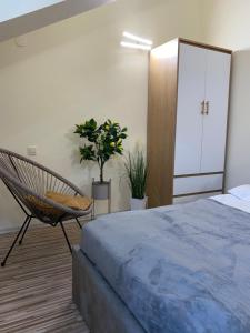 a bedroom with a bed and a chair at Garden Residence in Constanţa