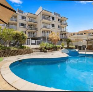 a swimming pool in front of a apartment building at Kings Beach Huge Private Rooftop Ocean Views Best Location in Caloundra