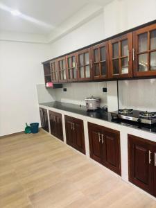 Una cocina grande con gabinetes de madera y piso de madera. en Spring View Holiday Home - 2nd Floor Apartment, en Badulla
