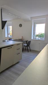 a white kitchen with a desk and a table at Moderne 3-Zimmer-Ferienwohnung direkt am Saaleradwanderweg in Halle an der Saale