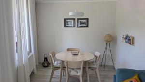 une salle à manger avec une table et des chaises blanches dans l'établissement Moderne 3-Zimmer-Ferienwohnung direkt am Saaleradwanderweg, à Halle-sur-Saale