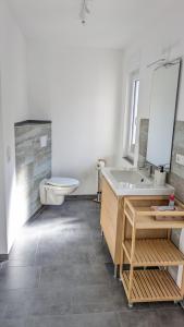 a bathroom with a sink and a toilet at Moderne 3-Zimmer-Ferienwohnung direkt am Saaleradwanderweg in Halle an der Saale +26 photos