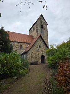 an old stone church with a bench in front of it at Moderne 3-Zimmer-Ferienwohnung direkt am Saaleradwanderweg in Halle an der Saale