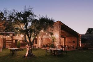 a group of tables and chairs in front of a building at Hotel Molí de l'Escala in L'Escala