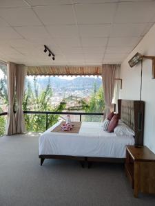 a bedroom with a large bed with a large window at Casa Encuentro San Blas in Cusco