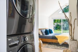 Cette chambre comprend un lit et un lave-linge/sèche-linge. dans l'établissement Driftwood on 6th Heritage Downtown Collingwood, à Collingwood