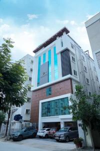 Un edificio con coches aparcados en un estacionamiento. en Vasatee Kondapur, en Kondapur