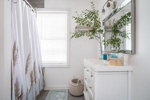 une salle de bain blanche avec un miroir et un lavabo dans l'établissement Driftwood on 6th Heritage Downtown Collingwood, à Collingwood 59 autres photos