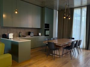 une cuisine et une salle à manger avec une table et des chaises en bois dans l'établissement Ambassadori kachreti Golf Resort, Villa 10, à Stantsiya Kachreti