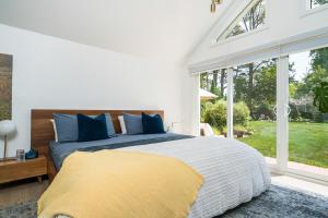 une chambre avec un grand lit et une fenêtre dans l'établissement Driftwood on 6th Heritage Downtown Collingwood, à Collingwood