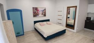 a small bedroom with a bed and a mirror at Cichy Zaułek 9A in Brodnica