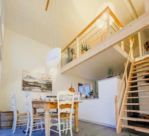 a kitchen and dining room with a wooden table and chairs at Modern Loft House In The Woods Near Gullabo in Gullabo +19 photos
