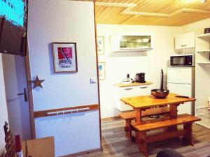 a small kitchen with a table and a refrigerator at Les Chalets de Mel in Saint-Lary-Soulan