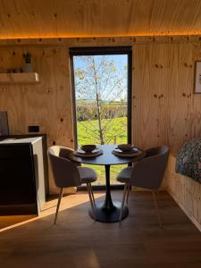 a table and chairs in a room with a window at Four Acres Farm in Donaghadee