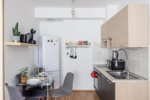 a small kitchen with a table and a refrigerator at Stylish City Stay in Budapest