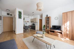 a living room with a table and a kitchen at Stylish City Stay in Budapest