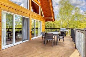 a wooden deck with a table and chairs on it at Henö in Mandeville