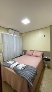 a bedroom with a bed with two towels on it at Apto 13 - Residencial Canaã in Porto Velho