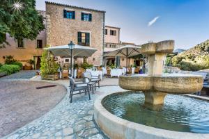 une fontaine au milieu d'un patio avec tables et chaises dans l'établissement Hotel Rural S'Olivaret & Spa, à Alaró
