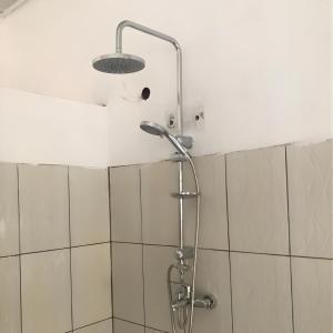 una ducha con cabezal de ducha en un baño en Jambo Guest House, en Taba